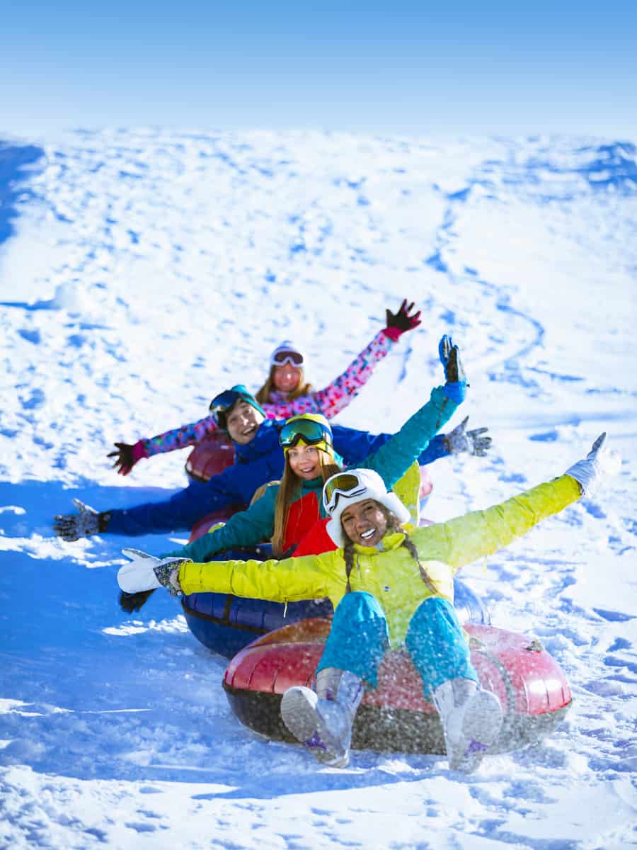 people riding snow tubing at winter park