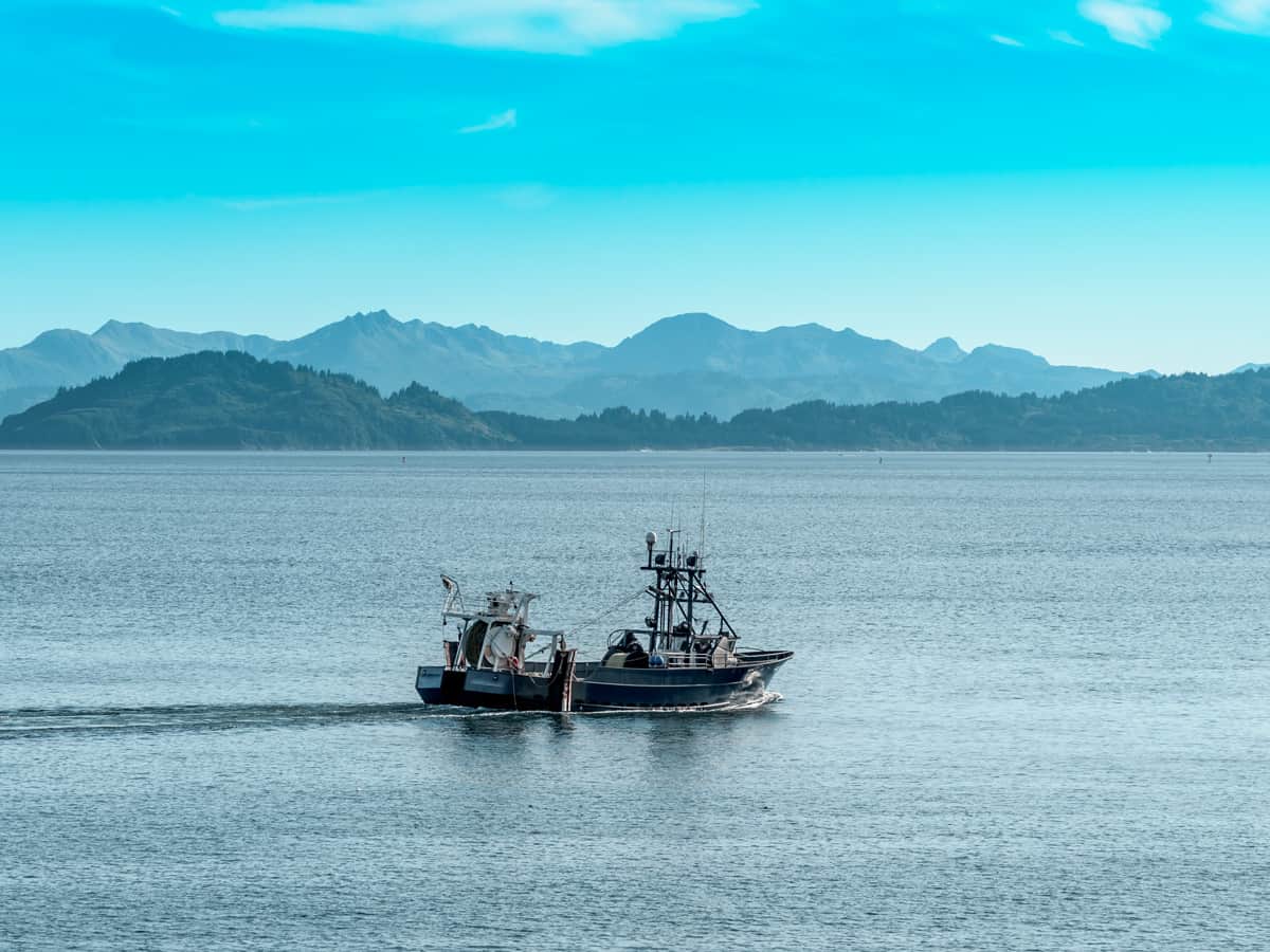 Crab Fishing Boat Leaving the Port of Kodiak Alaska with the Mountains in the Background