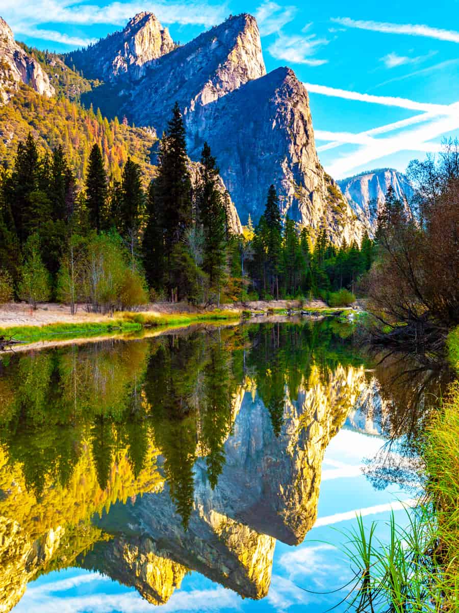 Early morning shot of the three brothers mountain range in Yosemite National Park in California taken in the Summer with reflections in the river bed below