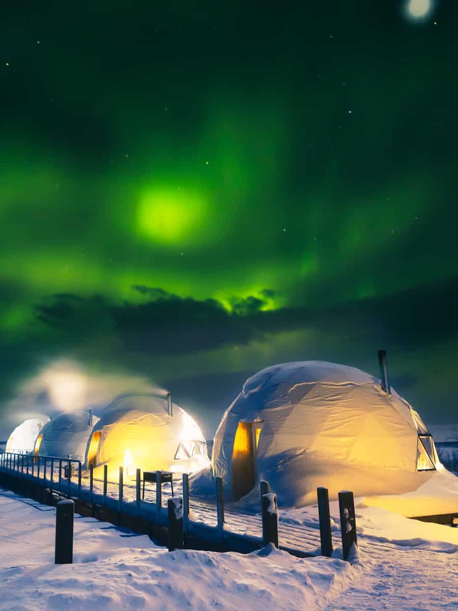 Northern Lights also known as aurora, borealis or polar lights at cold night over igloo village