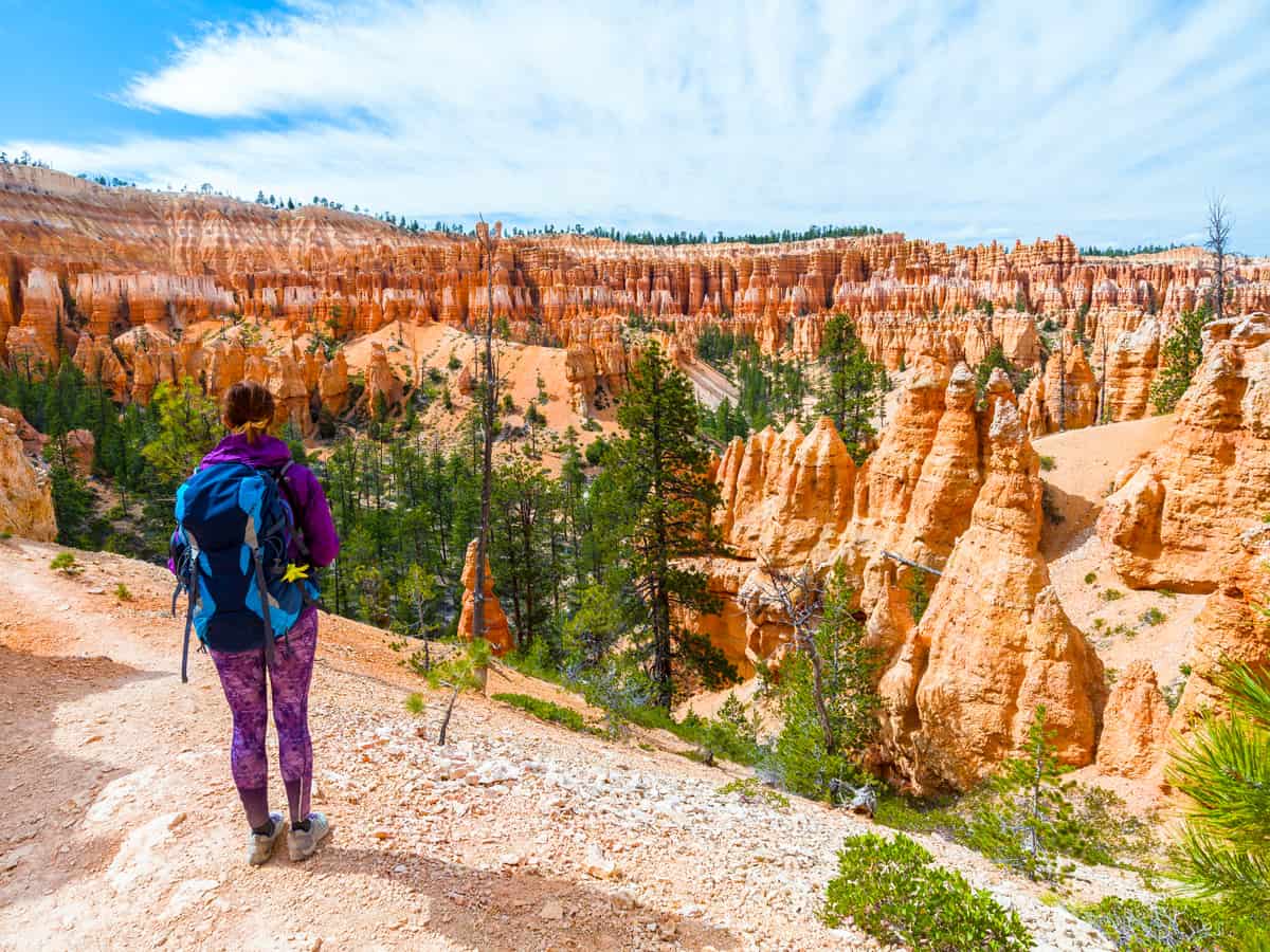 Hiker woman in Bryce Canyon hiking looking and enjoying view during her hike wearing hikers backpack