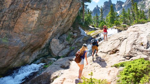 People hiking on Emerald Lake Trail. Friends exploring Colorado mountains. Estes Park, Rocky Mountains National Park, Colorado, USA 1600x900