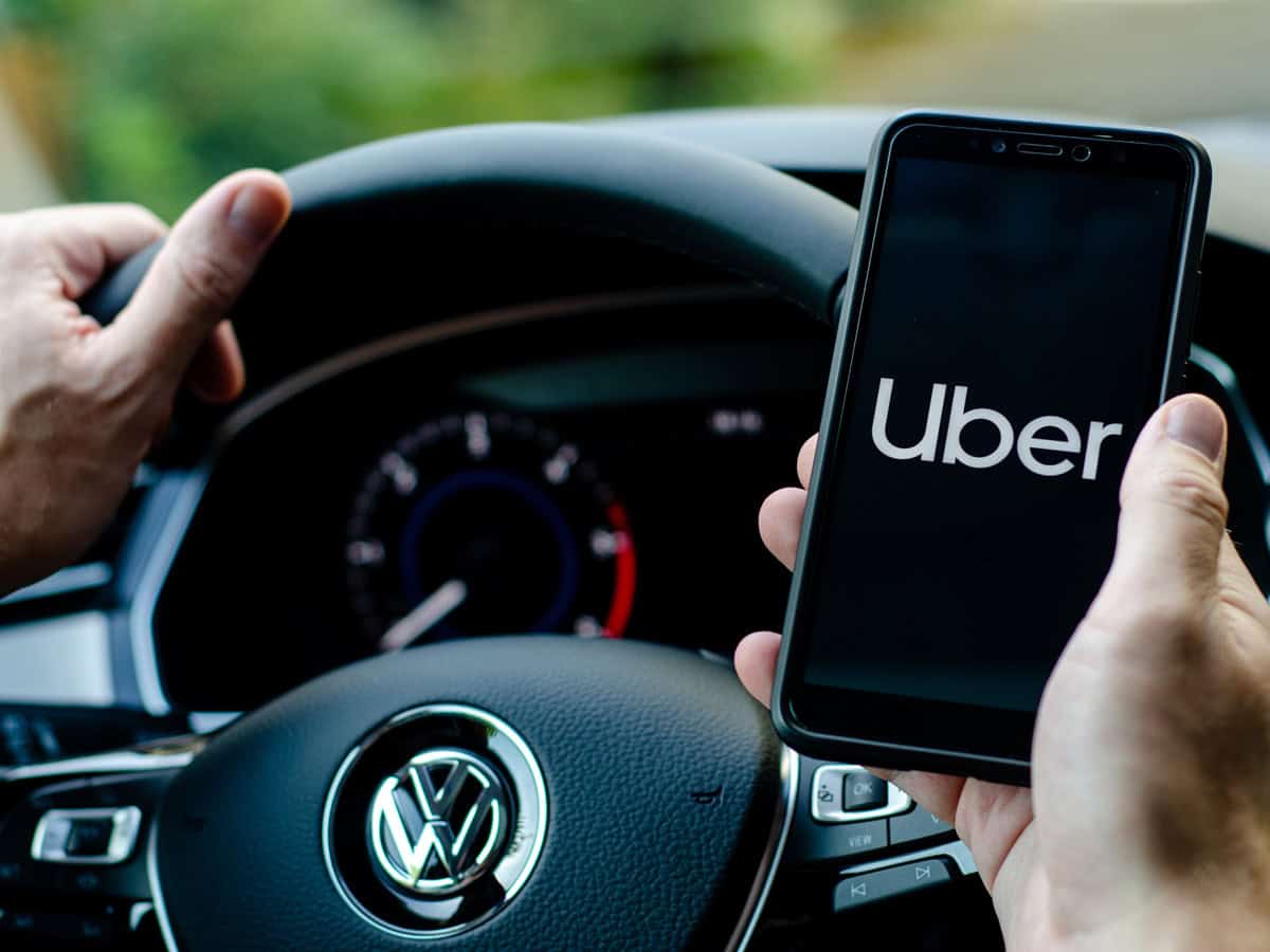  Uber driver holding smartphone in Volkswagen car
