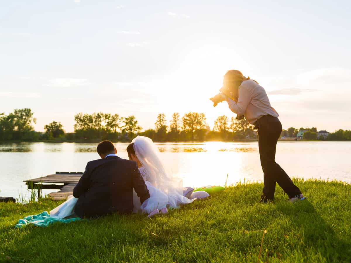 Wedding photographer photographs brides sitting on the lake